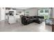 Open-concept space features a large gray sectional couch, kitchen, and dining area at 14532 Whitewater Way, Brooksville, FL 34604