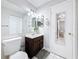 Bathroom with large mirror, dark wood cabinet, and nearby closet at 147 114Th Ne Ave # 147, St Petersburg, FL 33716