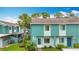 Exterior view of a bright blue two-story home with verdant landscaping and tropical trees at 147 114Th Ne Ave # 147, St Petersburg, FL 33716