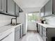 Charming kitchen with gray cabinets, white appliances, and a sunny window at 147 114Th Ne Ave # 147, St Petersburg, FL 33716