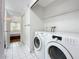 Convenient laundry room setup with washer and dryer units, nearby closet, and bedroom access at 147 114Th Ne Ave # 147, St Petersburg, FL 33716