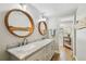 Bathroom with a double sink vanity featuring marble countertops, wood-framed mirrors, and wood look flooring at 150 Bosphorous Ave, Tampa, FL 33606