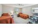 This bedroom features two twin beds, neutral walls, and ample natural light from the two large windows at 150 Bosphorous Ave, Tampa, FL 33606