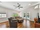 Cozy living room featuring hardwood floors, modern ceiling fan, and sliding glass doors to the pool at 150 Bosphorous Ave, Tampa, FL 33606