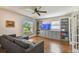 Cozy living room features hardwood floors, a gray sectional, custom built-ins, and a large window at 150 Bosphorous Ave, Tampa, FL 33606