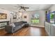 Bright living room with hardwood floors, gray sectional, custom built-ins, and large windows at 150 Bosphorous Ave, Tampa, FL 33606