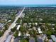 An aerial view captures the neighborhood's ocean view, mature landscaping, and surrounding commercial and residential areas at 1501 Howard Pl, Largo, FL 33770
