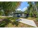 Exterior shot of home featuring a concrete pad and lush green yard, with trees in the background at 1501 Howard Pl, Largo, FL 33770
