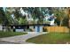 Charming single-story home boasts a blue door, a well-manicured lawn, and a private fenced yard at 1501 Howard Pl, Largo, FL 33770