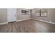 Bright living room with wood-look floors, new paint, white trim, and natural light at 1501 Howard Pl, Largo, FL 33770
