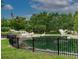 View of the pond with bird sculptures surrounded by a black fence, with flags and trees in background at 1501 Howard Pl, Largo, FL 33770