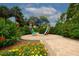 Outdoor view of a colorful heart sculpture surrounded by brick pavers, red hibiscus and marigolds at 1501 Howard Pl, Largo, FL 33770