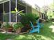 Private backyard features Adirondack chairs, lush landscaping and screened-in lanai at 1605 Send Way, Lutz, FL 33549