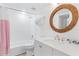 Modern bathroom with a round mirror, white subway tile, and a vanity with updated fixtures at 17334 Gulf Blvd # 203, North Redington Beach, FL 33708