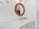 Bright bathroom features a vanity with modern fixtures, a round mirror, and unique towel rack at 17334 Gulf Blvd # 203, North Redington Beach, FL 33708