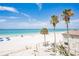 Scenic beach view framed by swaying palm trees, white sand, and the Gulf of Mexico at 17334 Gulf Blvd # 203, North Redington Beach, FL 33708