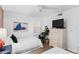 Bright bedroom with white furniture, twin beds, and a large flat screen television at 17334 Gulf Blvd # 203, North Redington Beach, FL 33708