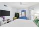 Well-lit bedroom boasts ample natural light, complete with dresser, mounted TV, and a peaceful ambiance for relaxation at 17334 Gulf Blvd # 203, North Redington Beach, FL 33708