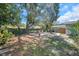 Inviting backyard featuring mature trees, an outdoor seating area, and a fire pit for relaxing evenings at 1841 Douglas Ave, Dunedin, FL 34698
