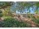 Lush backyard with a wood deck, perfect for outdoor dining and relaxing under the shade of mature trees at 1841 Douglas Ave, Dunedin, FL 34698