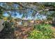 Spacious backyard offers a private setting, complete with seating and lush landscaping for serene outdoor living at 1841 Douglas Ave, Dunedin, FL 34698
