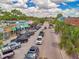 Bustling street view features a variety of businesses, active parking, and lush palm trees, capturing a vibrant community atmosphere at 1841 Douglas Ave, Dunedin, FL 34698