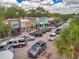 Charming street view with colorful storefronts, mature trees, and active street parking, showcasing a lively commercial district at 1841 Douglas Ave, Dunedin, FL 34698