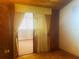 A bedroom featuring wood panel walls, carpeted floors, and curtains leading to a room with striped privacy screens at 20989 Negril, Lutz, FL 33558
