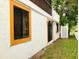 View of home's exterior with yellow window trim and white siding at 20989 Negril, Lutz, FL 33558