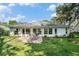 Landscaped backyard with stone patio, dining set, and views of the property at 2222 Westchester Blvd, Spring Hill, FL 34606