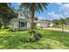 Landscaped home exterior featuring a lush green lawn and mature palm tree at 2222 Westchester Blvd, Spring Hill, FL 34606
