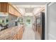 Open kitchen with stainless steel appliances, granite countertops, tile floors, and a view of the living room at 2222 Westchester Blvd, Spring Hill, FL 34606