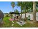Spacious backyard with outdoor kitchen, grill, and picnic table under a shaded structure for entertaining guests at 2329 Carrie Ct, Dunedin, FL 34698