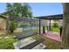 Large backyard boasts a covered outdoor kitchen, screened-in pool area, and a picnic table on the lawn at 2329 Carrie Ct, Dunedin, FL 34698
