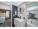 Bathroom with modern vanity, lighted round mirror, and decorative wall accents, with view into the bedroom at 2329 Carrie Ct, Dunedin, FL 34698