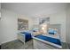 Bright bedroom featuring two twin beds with blue accents and wood-look tile flooring at 2329 Carrie Ct, Dunedin, FL 34698
