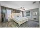 Spacious bedroom with wood-look accent wall, a queen-sized bed, and natural light from two windows at 2329 Carrie Ct, Dunedin, FL 34698