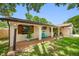 Charming one-story home featuring a brown two-car garage, well-maintained lawn, and inviting front porch area at 2329 Carrie Ct, Dunedin, FL 34698