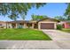 Charming one-story home featuring a brown two-car garage, well-maintained lawn, and inviting front porch area at 2329 Carrie Ct, Dunedin, FL 34698