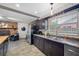 A view of the kitchen with stainless steel appliances, a double sink, a brick wall, and modern cabinetry at 2329 Carrie Ct, Dunedin, FL 34698
