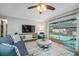 Cozy living room area features a plush sofa, bright rug, and a sliding door leading to the pool area at 2329 Carrie Ct, Dunedin, FL 34698