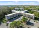 Aerial view of a condo building showcasing lush landscaping, ample parking, and surrounding greenery at 2461 Rhodesian Dr # 47, Clearwater, FL 33763