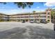 Multi-story condo building with a brick facade, balconies, and ample parking in a landscaped setting at 2461 Rhodesian Dr # 47, Clearwater, FL 33763