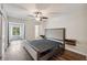Main bedroom with hardwood floors, en-suite bathroom, and view of the green space at 2461 Rhodesian Dr # 47, Clearwater, FL 33763