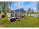 Spacious backyard with a screened patio, lush lawn and tropical landscaping at 25101 Hyde Park Blvd, Land O Lakes, FL 34639