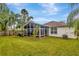 Great backyard with a screened-in patio, lush lawn, and tropical landscaping at 25101 Hyde Park Blvd, Land O Lakes, FL 34639