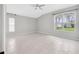 Bedroom features tiled floors, ceiling fan, and large windows letting in natural light at 25101 Hyde Park Blvd, Land O Lakes, FL 34639