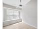 This bright bedroom features tiled floors, large window, and a ceiling fan at 25101 Hyde Park Blvd, Land O Lakes, FL 34639