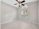 Well-lit bedroom with tiled floors, fan and large windows, offering a clean aesthetic at 25101 Hyde Park Blvd, Land O Lakes, FL 34639