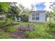 Backyard featuring trees, plants, screened patio and manicured lawn at 26343 Whirlaway Ter, Wesley Chapel, FL 33544